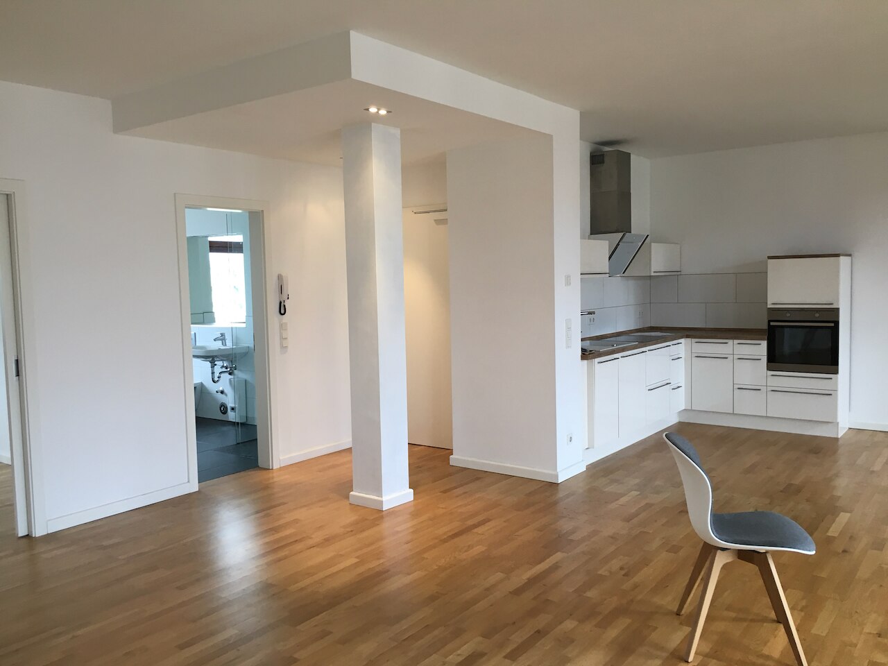 Helle, leere Wohnung mit Parkett und Küche