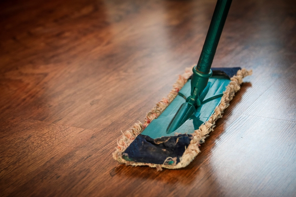 Wischmopp auf glänzendem Holzboden